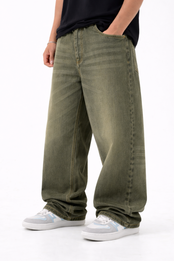 Men wearing olive green oversized fit denim jeans with relaxed streetwear style and casual sneakers.